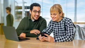 Man And Woman Looking At Phone © Miles More