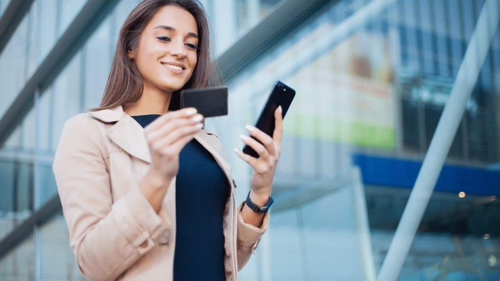 Frau hält schwarze Kreditkarte in der Hand